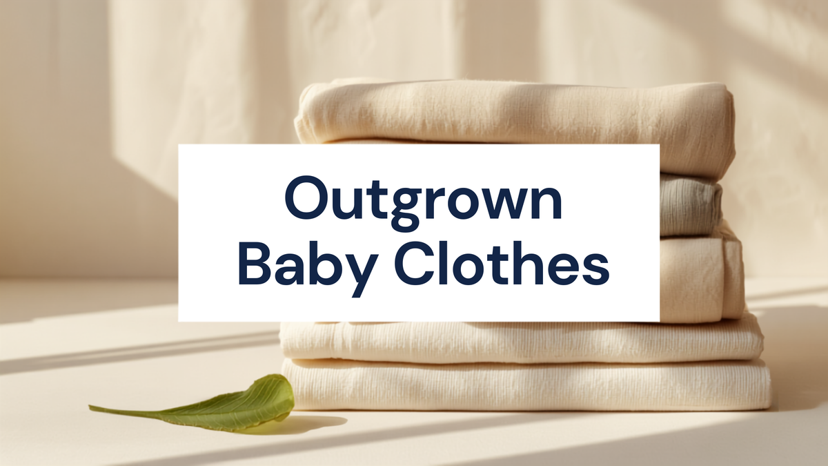 Outgrown baby clothes banner showing a neatly folded stack of organic cotton baby clothes with a green leaf sprig