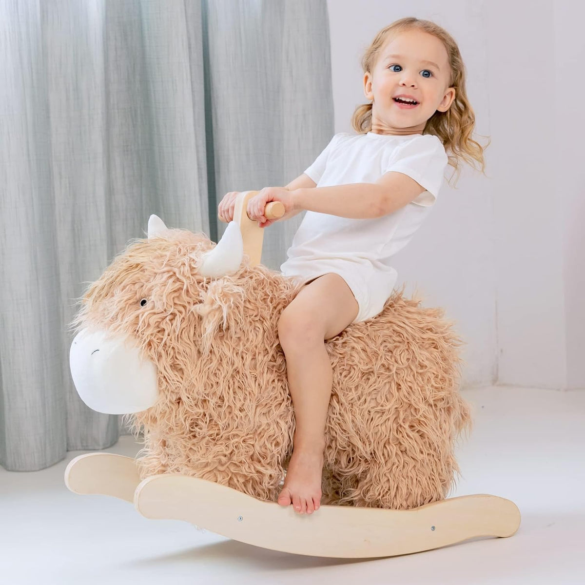 Jolie Vallee baby rocking horse shaped like a plush yak on a solid wood rocker with handles